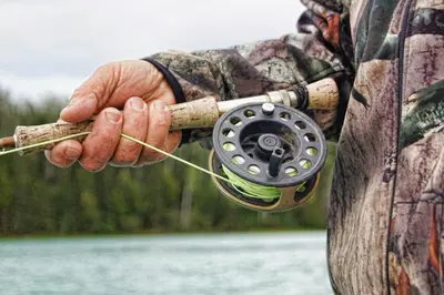 a man holding a fishing rod in his hand at Valyspruit Trout Fishing and Game Retreat in Dullstroom
