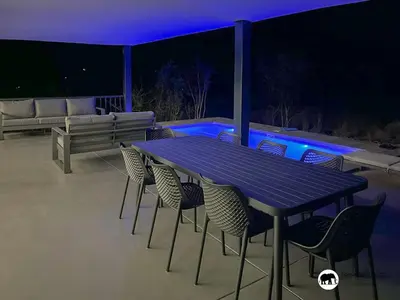 a table and chairs on a patio at night at 99 on Zwartkloof - Luxury Bushveld Retreat in Warmbaths