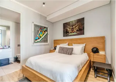 a bedroom with a large white bed and a desk at Modern Bachelor Suite & Stunning View Pool & Gym in Midrand