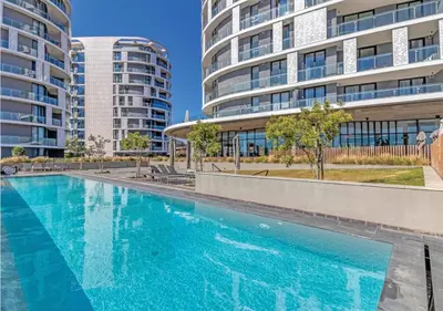an empty swimming pool in front of two tall buildings at Modern Bachelor Suite & Stunning View Pool & Gym in Midrand