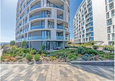 an apartment building with a garden in front of it at Modern Bachelor Suite & Stunning View Pool & Gym in Midrand