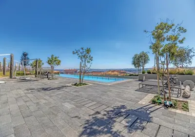a patio with a swimming pool and trees and a pool at Modern Bachelor Suite & Stunning View Pool & Gym in Midrand
