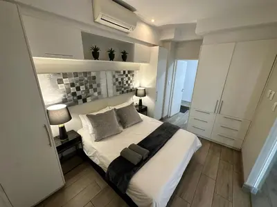 a bedroom with a large white bed with two pillows at Stay at Regency Luxe One in Pretoria