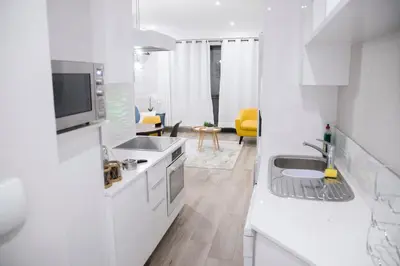 a white kitchen with a sink and a microwave at Stay at Regency Luxe One in Pretoria