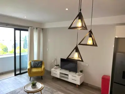 a living room with a tv and a yellow chair at Stay at Regency Luxe One in Pretoria