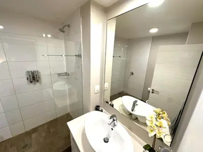 a bathroom with a sink and a shower and a mirror at Stay at Regency Luxe One in Pretoria