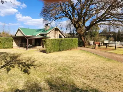 a house with a green roof and a large yard at Big Oak Cottages in Dullstroom