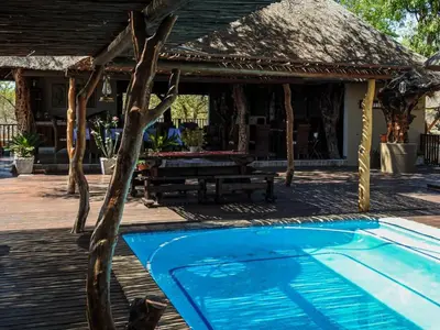 a resort with a pool and a picnic table at Mazuri Shamba Lodge in Phalaborwa