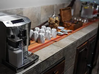 a row of coffee cups on a counter next to a coffee machine at Mazuri Shamba Lodge in Phalaborwa