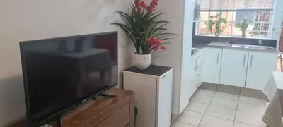 a living room with a television and a potted plant at Jenkins Re-Treat in Pretoria