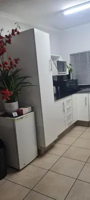 a kitchen with white cabinets and a potted plant at Jenkins Re-Treat in Pretoria