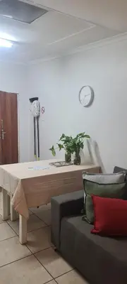 a living room with a couch and a clock on the wall at Jenkins Re-Treat in Pretoria