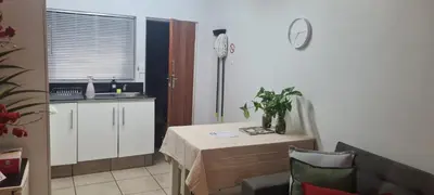 a kitchen with a table and a kitchen with a sink at Jenkins Re-Treat in Pretoria