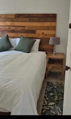 a bedroom with a bed and a table with a lamp at Jenkins Re-Treat in Pretoria