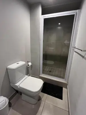 a small bathroom with a toilet and a shower at The 210 Circa Pretoria Studio in Pretoria