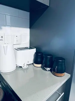a kitchen counter with three blue pots and a toaster at The 210 Circa Pretoria Studio in Pretoria