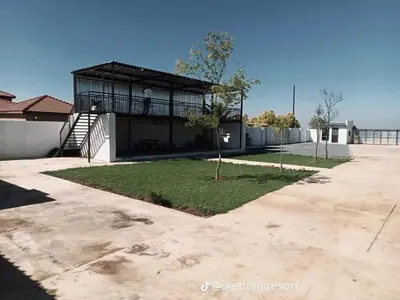 a house with a balcony and a yard at Iketleng Guest House & Resort