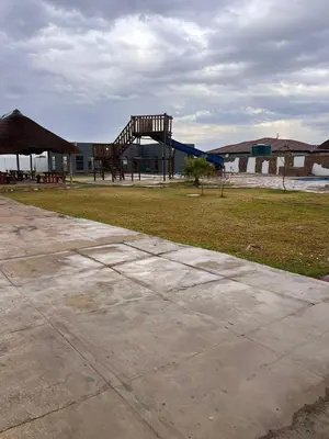 a park with a wooden structure in the grass at Iketleng Guest House & Resort