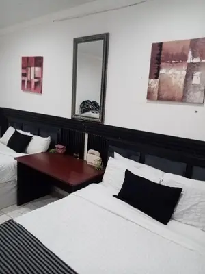 a bedroom with two beds and a table and a mirror at M and E Lodge in Enkelbosch
