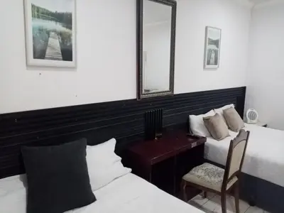 a bedroom with two beds and a desk and a mirror at M and E Lodge in Enkelbosch