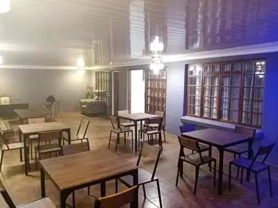 a restaurant with tables and chairs in a room at M and E Lodge in Enkelbosch