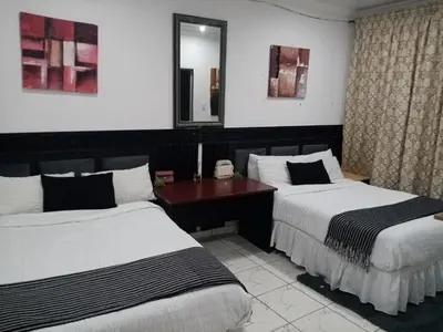 a hotel room with two beds and a mirror at M and E Lodge in Enkelbosch
