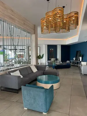 a living room with a couch and a chandelier at Penthouse On Tropical - The Blyde in Pretoria