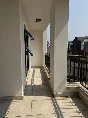 an empty hallway of a white building with windows at Penthouse On Tropical - The Blyde in Pretoria