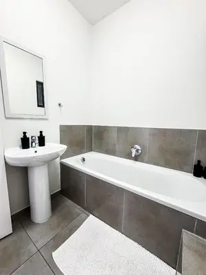 a bathroom with a sink and a tub and a mirror at Executive Apartment at Waterfall Ridge in Midrand