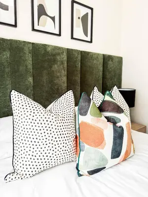 a bedroom with pillows on a bed with a green headboard at Executive Apartment at Waterfall Ridge in Midrand