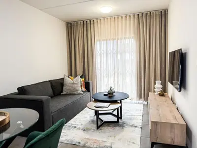 a living room with a couch and a table at Executive Apartment at Waterfall Ridge in Midrand