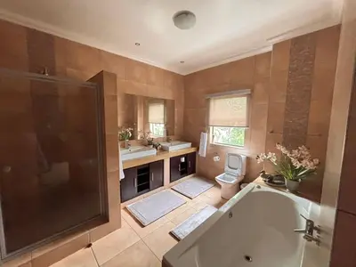 a bathroom with a tub and a sink and a toilet at Euphoria Self Catering Home in Naboomspruit