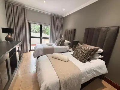 a bedroom with two beds and a window at Euphoria Self Catering Home in Naboomspruit