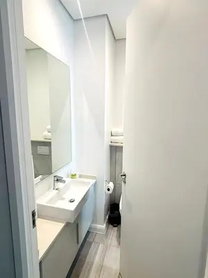 a white bathroom with a sink and a mirror at Menlyn Maine Residences - Capital Trilogy in Pretoria