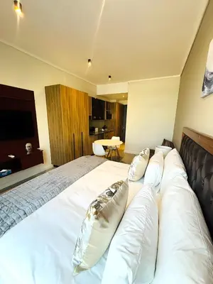 a bedroom with a large white bed with pillows at Menlyn Maine Residences - Capital Trilogy in Pretoria