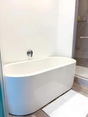 a white bath tub in a bathroom with a shower at Menlyn Maine Residences - Capital Trilogy in Pretoria