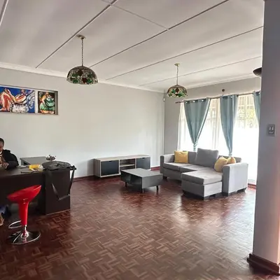 a living room with a couch and a table at MBT Lodge in Polokwane