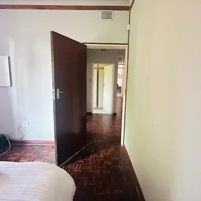 a bedroom with a door leading into a hallway at MBT Lodge in Polokwane