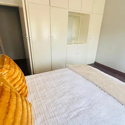 a bedroom with a bed with a white bedspread at MBT Lodge in Polokwane