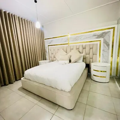 a bedroom with a large bed with white sheets and pillows at The Blyde Crystal lagoon in Pretoria