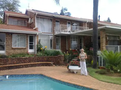 a woman standing in front of a house with a bath tub at Viva-Africa in Pretoria