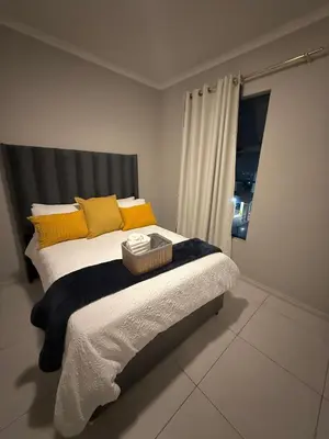 a bedroom with a large bed with yellow pillows at Charlsi luxury in Midrand