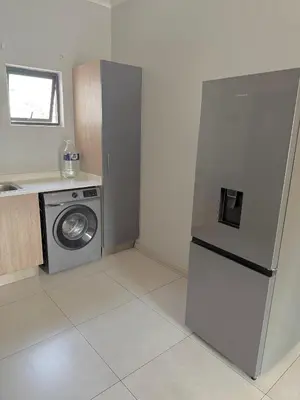 a kitchen with a refrigerator and a washing machine at Charlsi luxury in Midrand