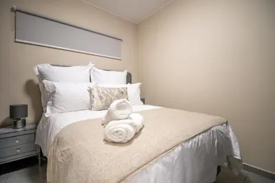 a bedroom with a bed with towels on it at Waterfall Ridge Luxurious Apartments - Backup Power! in Midrand