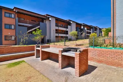 a brick bench in front of a building at Waterfall Ridge Luxurious Apartments - Backup Power! in Midrand