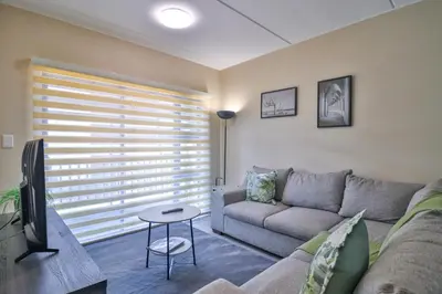 a living room with a couch and a tv at Waterfall Ridge Luxurious Apartments - Backup Power! in Midrand