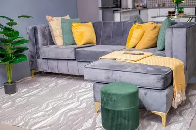 a living room with a blue couch with yellow and green pillows at SinoVilla397 in Pretoria