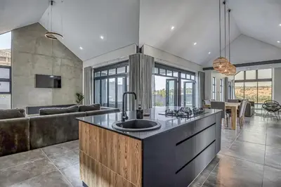 a kitchen with a sink and a living room at The Waterkloof Gables in Pretoria