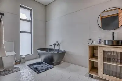 a bathroom with a tub and a sink at The Waterkloof Gables in Pretoria