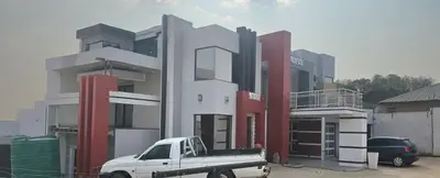 a white truck parked in front of a building at TURFLOOP guest house in Mankweng